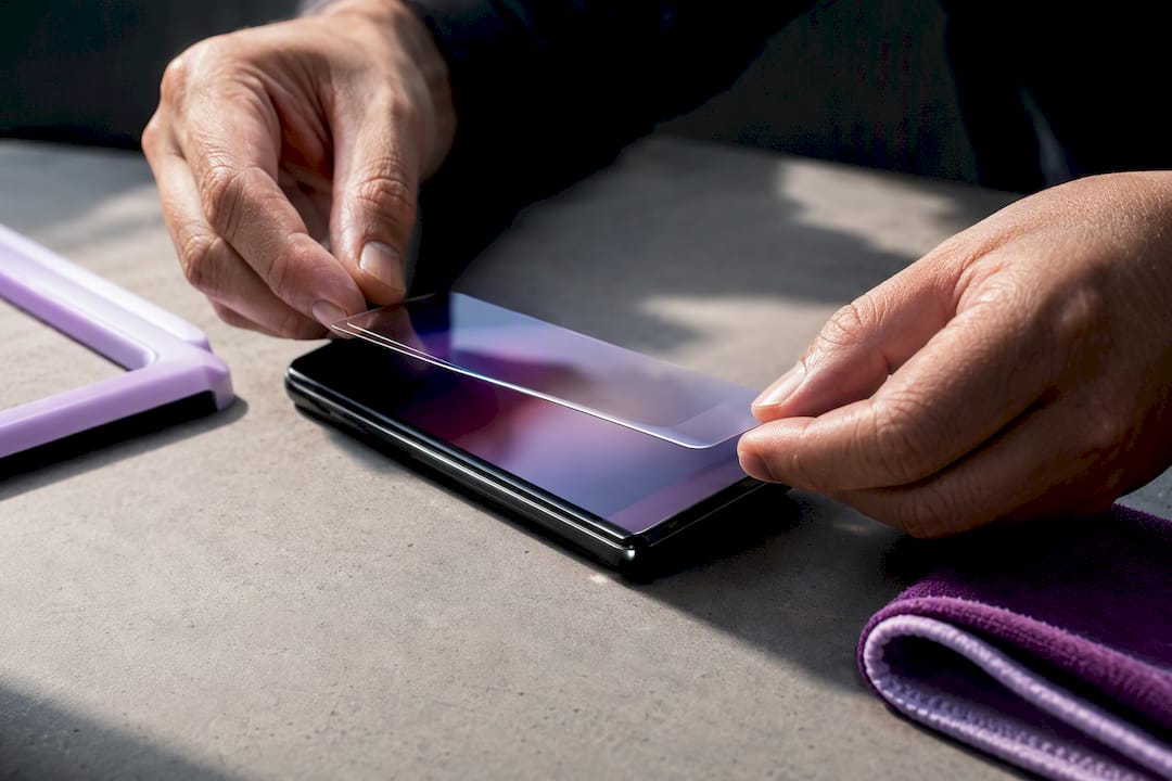 Hands aligning a curved screen protector