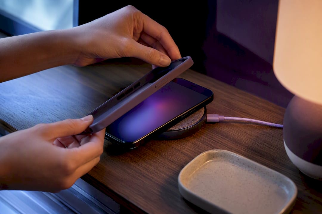 Hands removing case from charging phone
